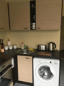 塔林Liivalaia Apartment的厨房配有洗衣机和水槽