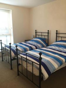 斯特利特Flat 2的卧室内的两张床,配有蓝色和白色的床单