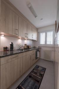 阿劳Muhusin Apartments的厨房配有木制橱柜和地板上的地毯。