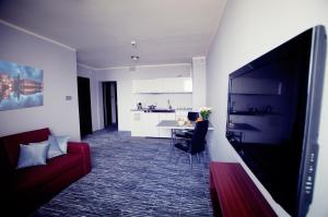弗罗茨瓦夫拉斯科酒店的客厅配有红色沙发和电视