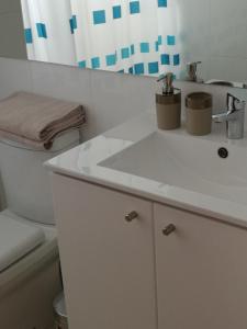 圣地亚哥Excelente departamento en Las Condes的浴室配有白色水槽和卫生间。