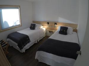小智利Cabañas El Engaño的酒店客房设有两张床和窗户。