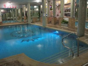 布莱顿霍夫皇后酒店&SPA的大楼内一个蓝色的大型游泳池