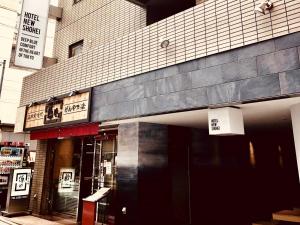 东京Hotel New Shohei的建筑物前面的商店,上面有标志