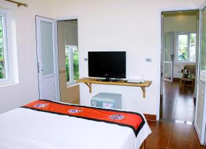 宁平CucPhuong Resort的一间卧室配有一张床和一台平面电视