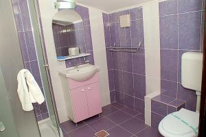 曼加利亚Vila Maritimo的紫色浴室设有水槽和卫生间
