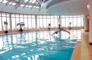 上海上海海神诺富特大酒店的跳入建筑物游泳池的人