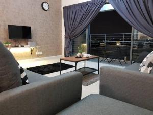 普崇Puchong 8-12 pax 5min LRT Cozy Apartment IOI Mall的客厅配有沙发和桌子