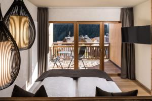 瓦勒斯法肯斯特诺温泉酒店的一间卧室配有一张床,阳台配有桌子