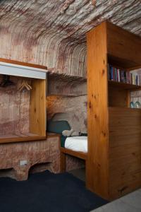 库伯佩迪Ali's Underground Studio的一间卧室设有一张床和一个书架
