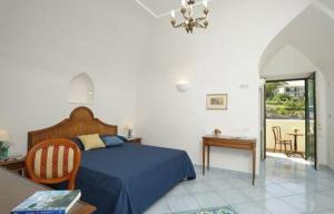 拉维罗艾尔杜卡托蒂拉维洛酒店的一间卧室配有一张蓝色的床和一张桌子