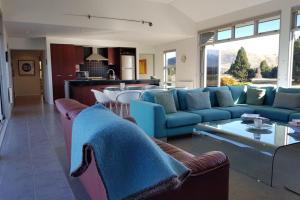 特卡波湖Tekapo Retreat的一间带蓝色沙发的客厅和一间厨房
