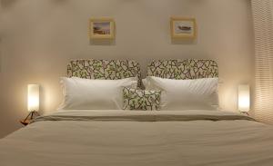 新德里99号简易别墅的一间卧室配有一张带两盏灯的大型白色床。
