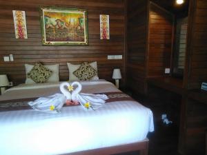 蓝梦岛Gatri Hut的一间卧室配有两张带白色连衣裙的床。