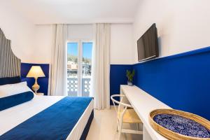 耶奥伊乌波利斯Georgioupolis Plaza Suites的蓝色和白色的卧室设有1张床和1台电视
