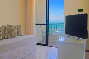 弗洛里亚诺波利斯棕榈滩公寓式酒店的带电视的客厅和海景阳台。