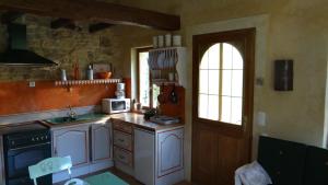 雷穆兰勒马泽特度假屋的厨房配有白色橱柜、水槽和窗户。
