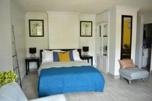 欧丘里欧Ambleside & Turtle beach towers的一间卧室配有蓝色的床和椅子