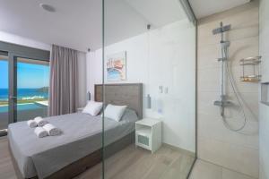 林都斯Villa Gaia的一间卧室设有淋浴和一张带毛巾的床。