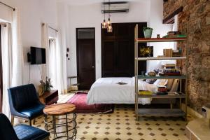 巴拿马城Small loft at Casa Neuman, Casco Antiguo的卧室配有1张床、1张桌子和1把椅子