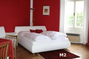 沃尔特湖畔韦尔登Seeappartements Excelsior的卧室配有红色墙壁上的白色床