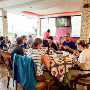 巴克里索莫雷诺港Galápagos Eco Friendly的一群坐在餐厅桌子上的人