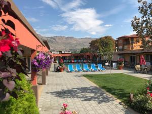 奥索尤斯Sahara Courtyard Inn & Suites Osoyoos的山间小屋,配有桌椅