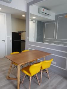 吉隆坡Robertson by MiRic的一间带木桌和黄色椅子的用餐室