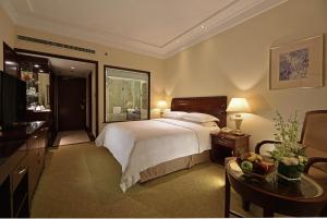 上海上海国际贵都大饭店的一间卧室配有一张大床、一张桌子和一张桌子。