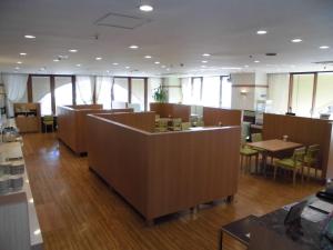 成田成田U-城市酒店的一间设有桌子和桌子及窗户的等候室
