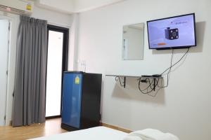莱卡邦苏瓦纳普米WJ酒店的一间墙上配有电视的房间和一张床