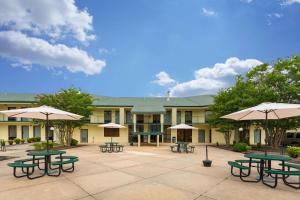 Heber SpringsQuality Inn & Conference Center的建筑前的庭院设有野餐桌和遮阳伞