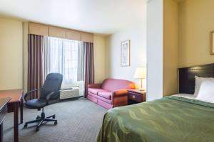 Alma阿尔玛品质酒店的酒店客房配有一张床、一张桌子和一把椅子。