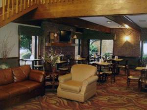 瑟西Quality Inn & Suites Searcy I-67的一间带沙发和桌椅的餐厅