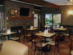 瑟西Quality Inn & Suites Searcy I-67的一间带桌椅和壁炉的餐厅