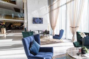 萨拉热窝萨拉热窝瑞士酒店的大堂设有蓝色的椅子和桌子