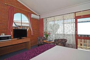 巴拉腊特Main Lead Ballarat Motel的一间卧室设有一张床、一台电视和一个窗口。