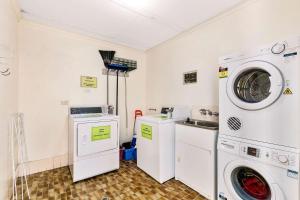赫维湾赫维主湾康夫特汽车旅馆的洗衣房配有两台机器和一台洗衣机和烘干机