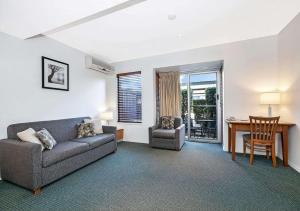 布里斯班Comfort Inn & Apartments Northgate Airport的客厅配有沙发和桌子
