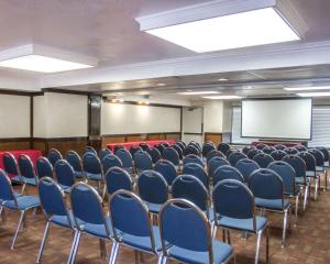 里弗赛德加州大学河滨分校和市区附近河滨品质酒店的一间会议室,配有蓝色椅子和白色屏幕