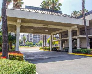 里弗赛德加州大学河滨分校和市区附近河滨品质酒店的一座大型建筑,设有棕榈树停车场