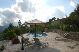 埃尔加斯托尔拉嘉因农家度假屋的一个带椅子和遮阳伞的庭院和一个游泳池