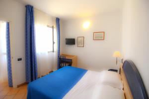 兰佩杜萨法国圣骑士酒店的卧室配有蓝色和白色的床和窗户。