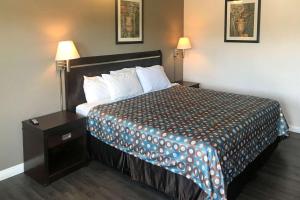 瓜斯蒂安大略米尔斯购物中心罗德威旅馆的酒店客房设有一张大床和一个床头柜。