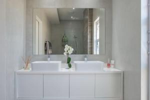 斯泰伦博斯29 Earlibelle的一间带两个盥洗盆和大镜子的浴室