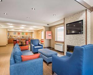 巴瑟斯特巴瑟斯特舒适酒店的一间设有蓝色椅子和平面电视的等候室