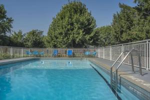 尼亚加拉瀑布罗德维法斯维假日酒店的一个带蓝色椅子和围栏的游泳池