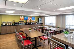 艾伯特亲王城Comfort Inn Prince Albert的餐厅设有木桌和红色椅子