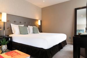 伦敦K西酒店&SPA的酒店客房设有一张白色大床和镜子