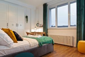 什切青Szczecin Old Town Apartments - 2 Bedrooms Deluxe的一间卧室设有一张床和一个大窗户